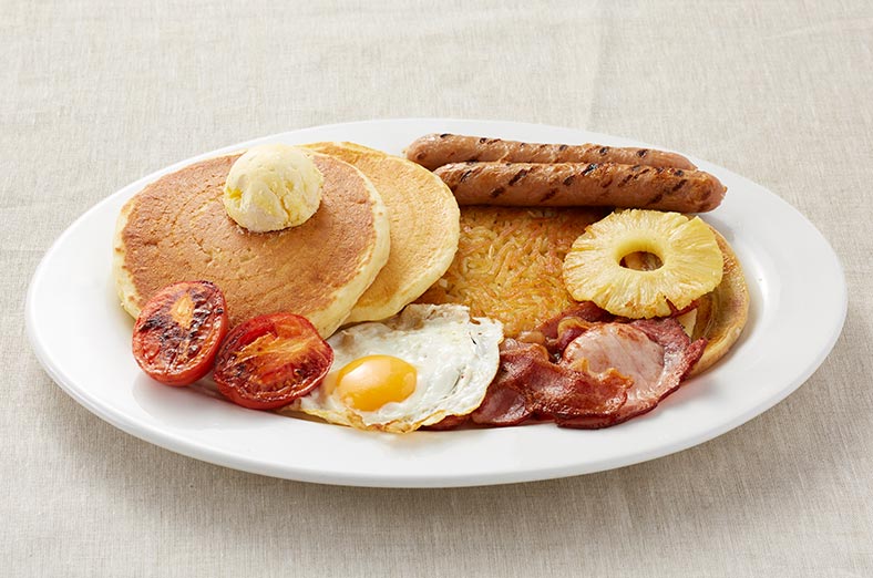 Pancakes, hashbrown, eggs, sausages, tomatoes